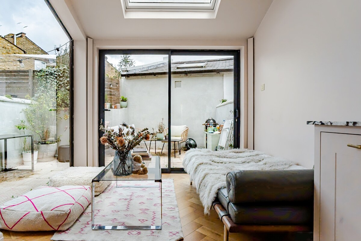 Garden room with vintage leather daybed and floor cushions